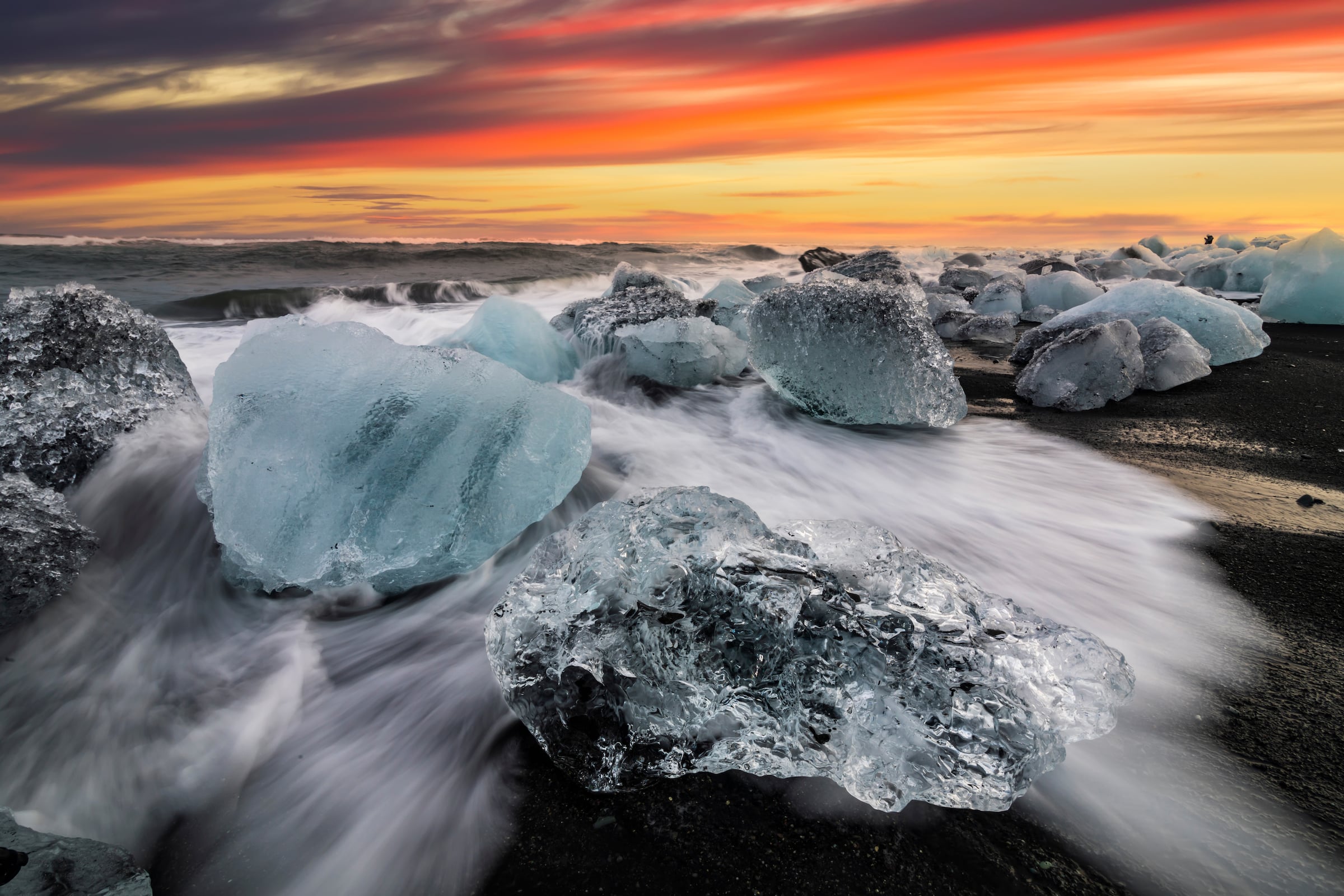 Roche de glace et sable noir sur la plage de Jokulsarlon au coucher du soleil. Plage de diamants dans le sud-est de l'Islande.