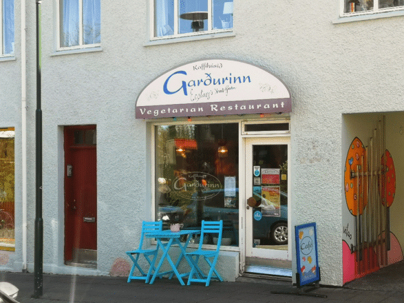 Dos sillas azules frente al restaurante Garðurinn en Reykjavík