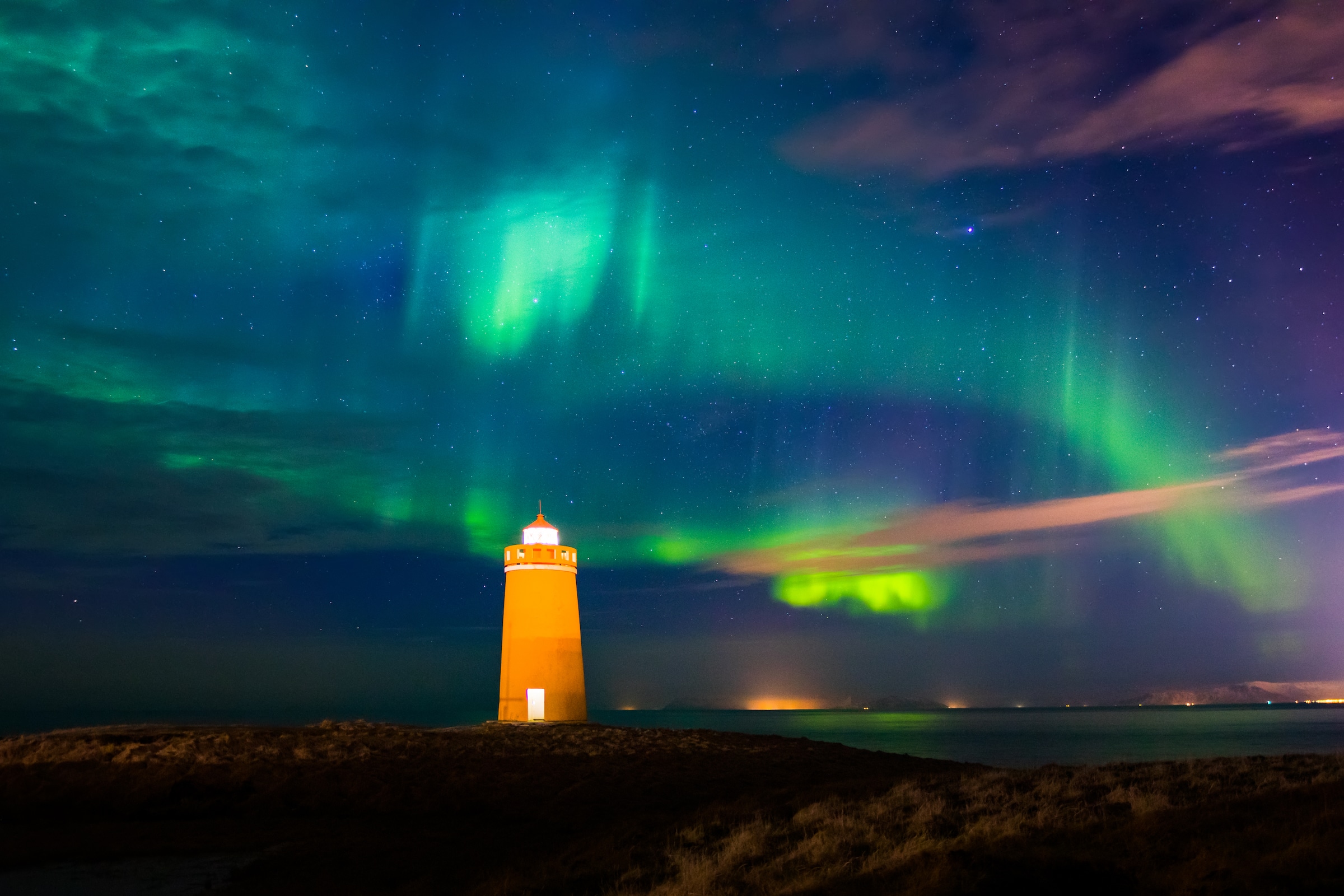 Hómbergsviti Lighthouse under northern lights on the Reykjanes Peninsula, Iceland.