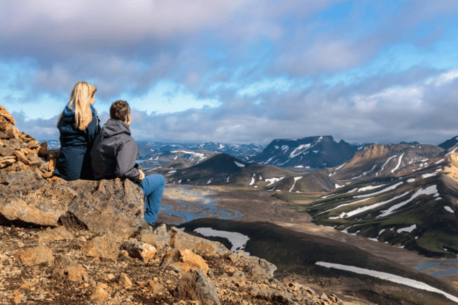 Dos personas mirando las montañas de las Tierras Altas de Islandia.