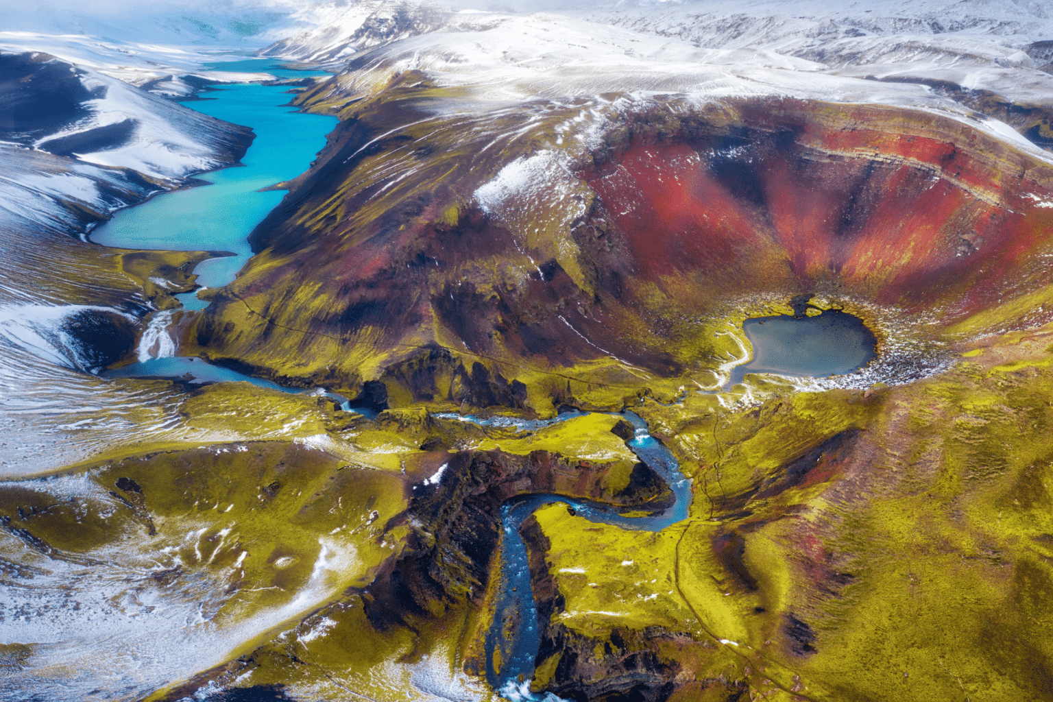 An arial photo of colorful mountains and blue lake at Landmannalaugar, Iceland.