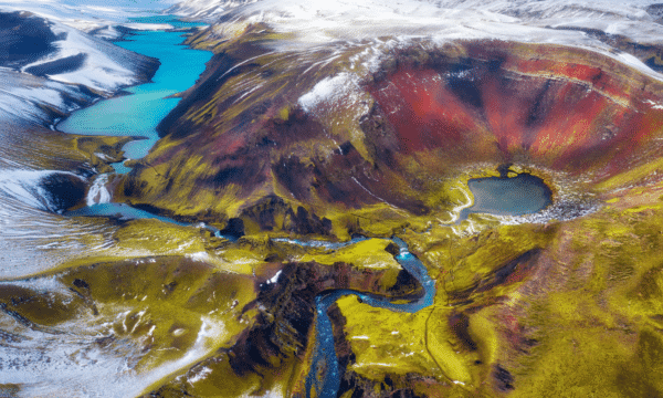 An arial photo of colorful mountains and blue lake at Landmannalaugar, Iceland.