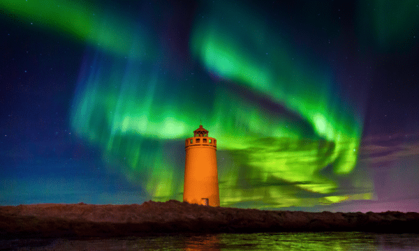 A lighthouse in Iceland under the Northern Lights.