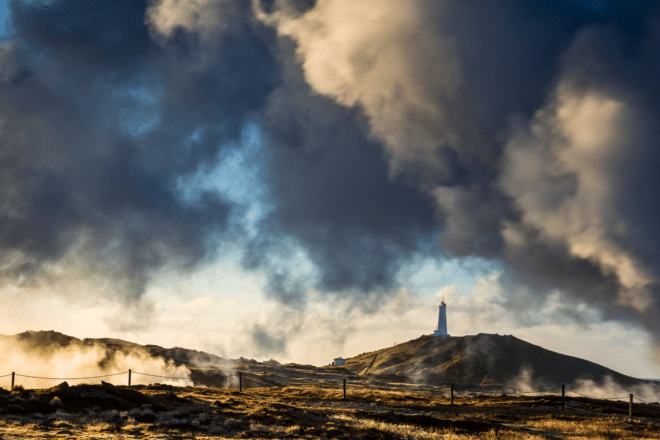 Una vista del faro de Reykjanesviti en Islandia, rodeado de vapor de las aguas termales de Gunnuhver.