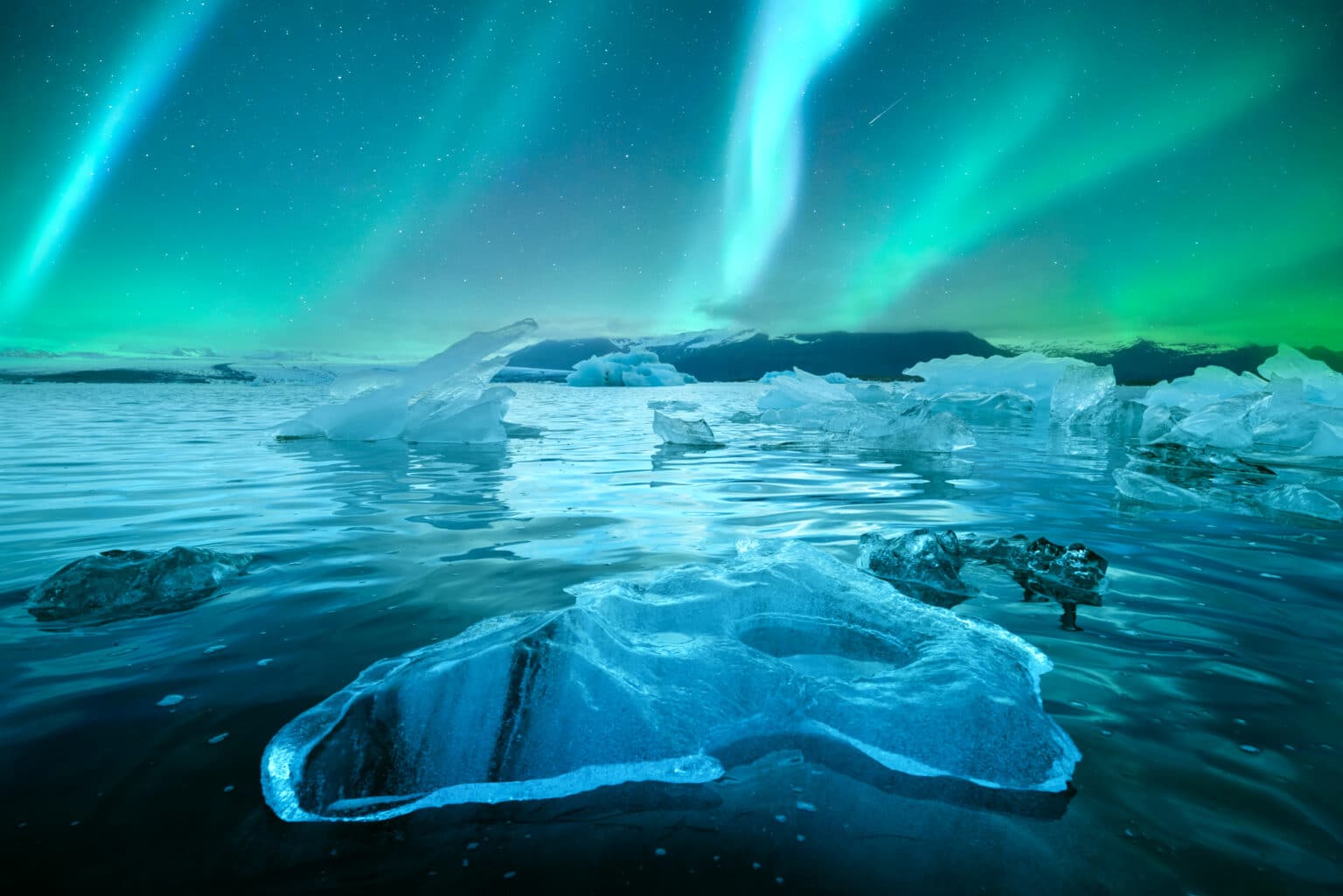Aurores boréales sur les icebergs de la lagune glaciaire de Jökulsárlón, en Islande.