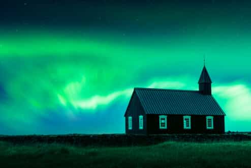 Aurores boréales au-dessus de l'église noire de Búðarkirkja, sur la péninsule de Snæfellsnes en Islande.