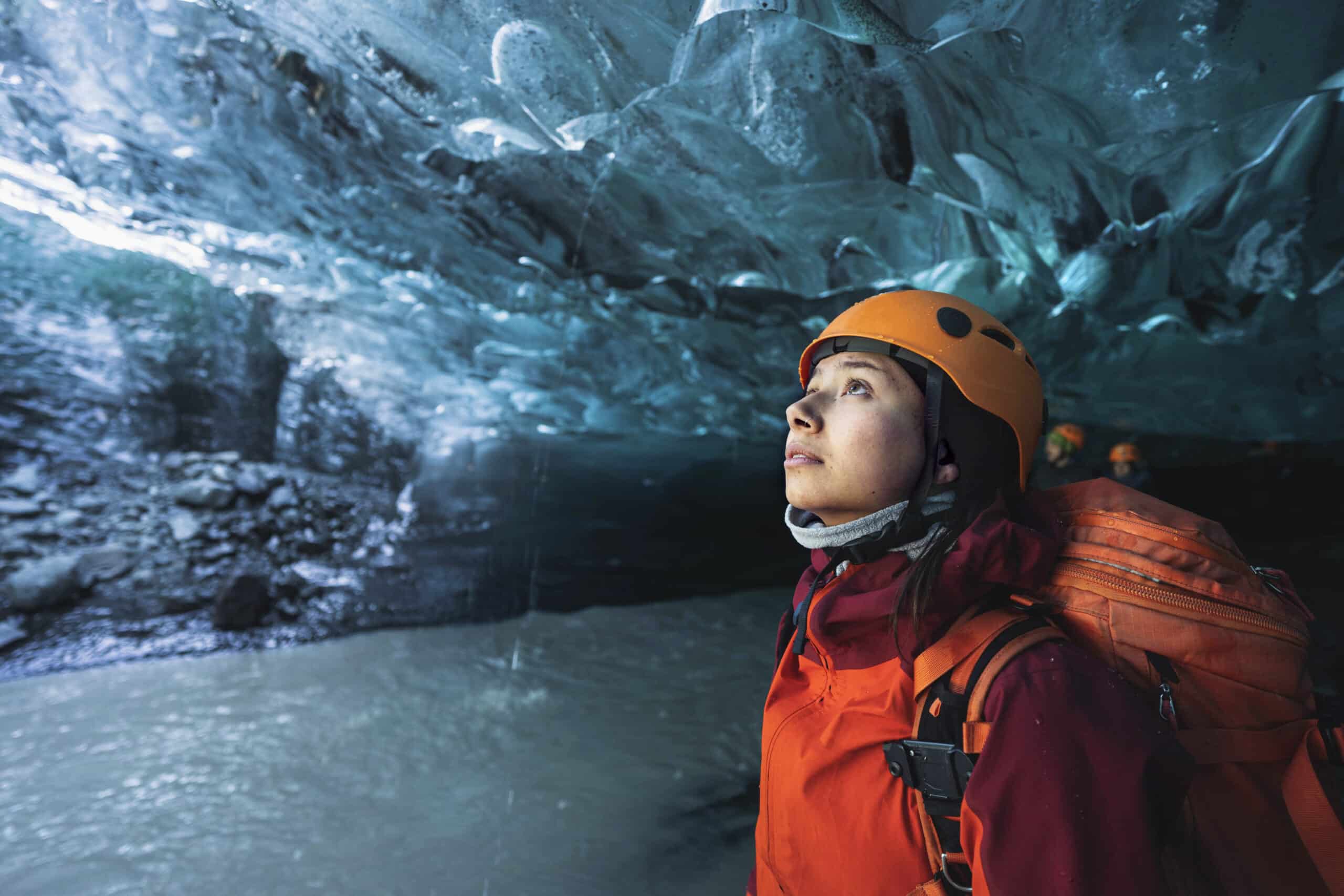 Explorador femenino en la cueva de hielo, Islandia
