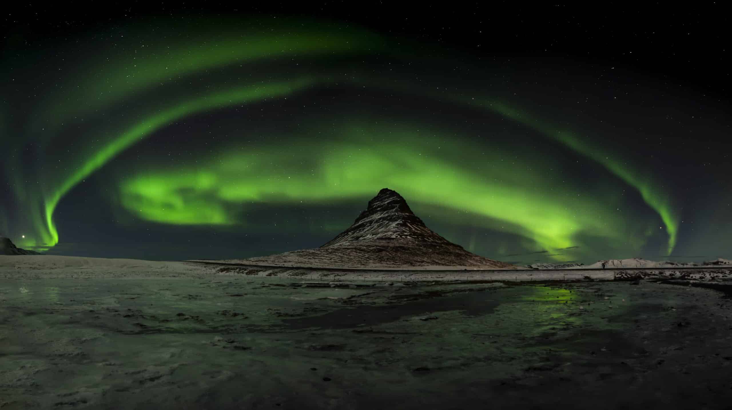 Aurora boreal sobre el nevado monte Kirkjufell en la península de Snæfellsnes en Islandia.