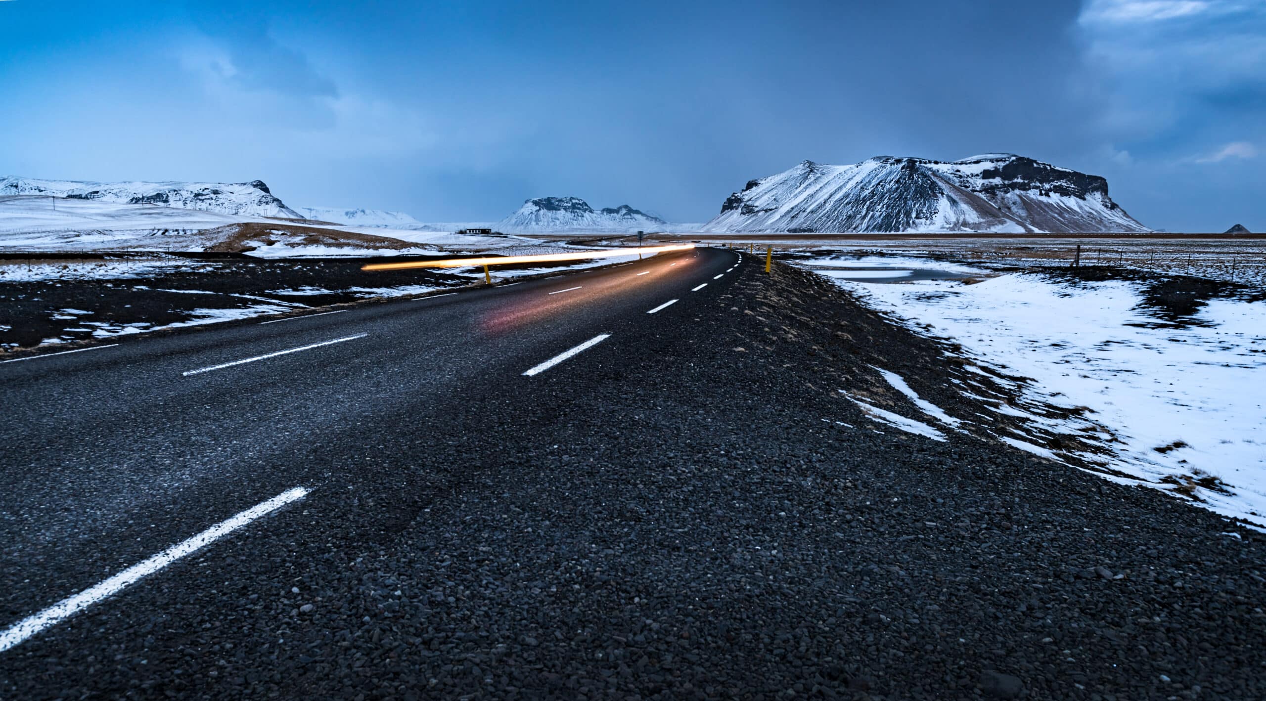 Hermoso paisaje invernal, carretera vacía con caminos nevados a su alrededor, vacaciones de viaje por carretera en invierno en Islandia
