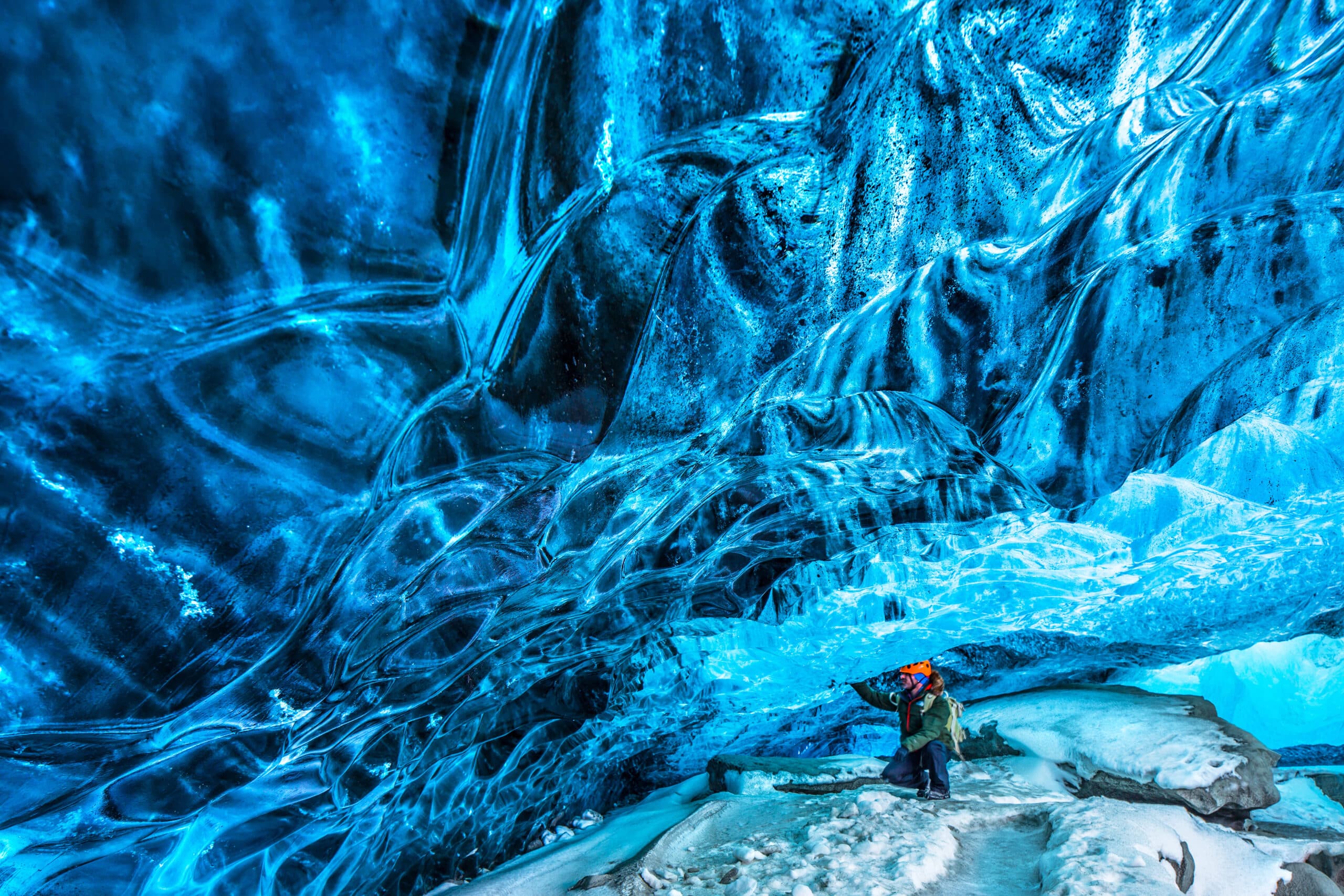 Turista descubriendo la cueva de hielo, viajero activo disfrutando de la belleza de una cueva glacial, vacaciones extremas de invierno, parque nacional Skaftafell, Vatnajokull, Islandia