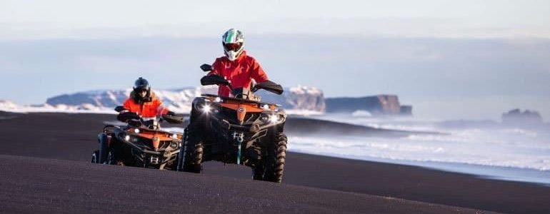 dos vehículos todo terreno en una playa de arena negra en el sur de Islandia