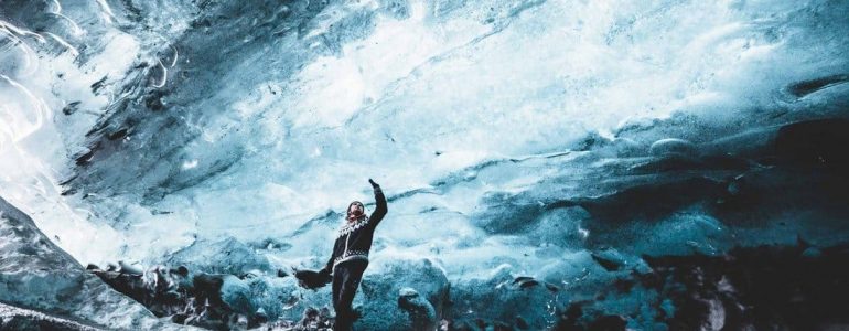 Un hombre de pie dentro de una cueva de hielo en Islandia
