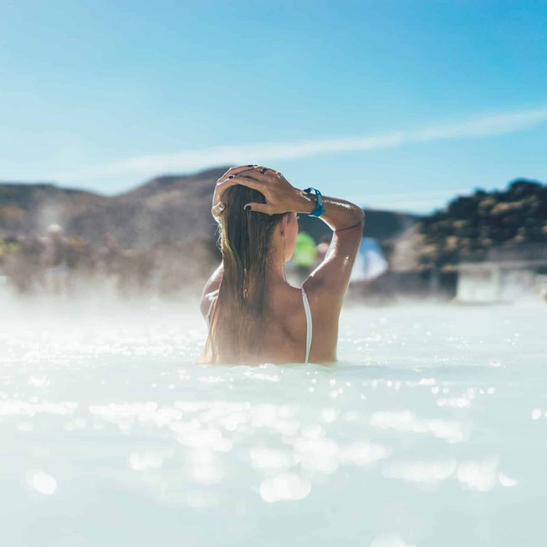 back view of young woman relaxing in the Blue Lagoon, Iceland