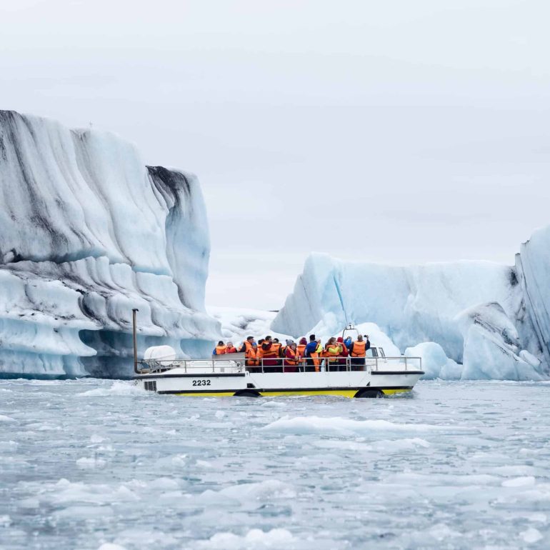 A boat floating amongst icebergs at Jokulsarlon Glacier Lagoon, Iceland.