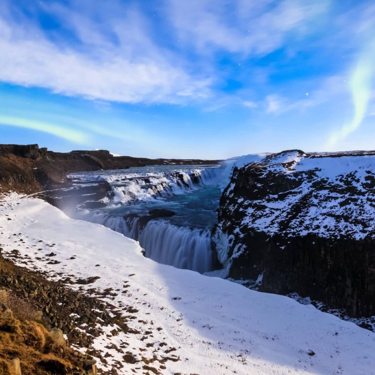 Northern Lights above snow-covered Gullfoss Waterfall on Iceland's Golden Circle.
