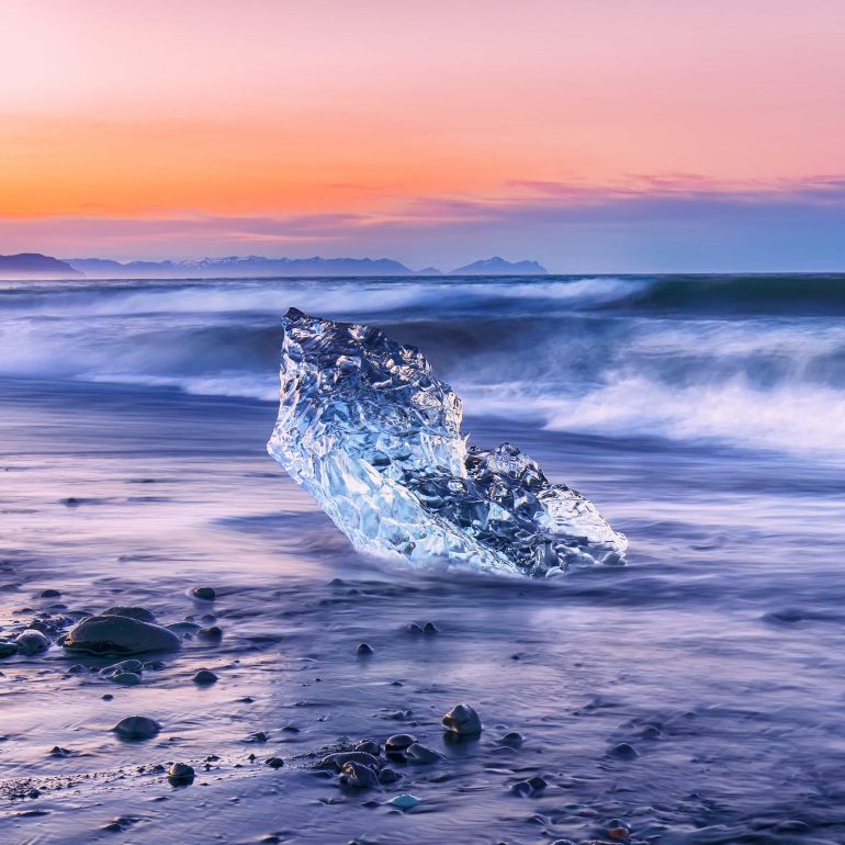 Piece of an iceberg on the Diamond Beach at Jokulsarlon lagoon during sunset.