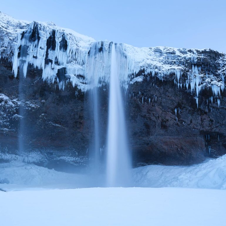 Snow and frost surrounding Seljalandsfoss waterfall in South Iceland.