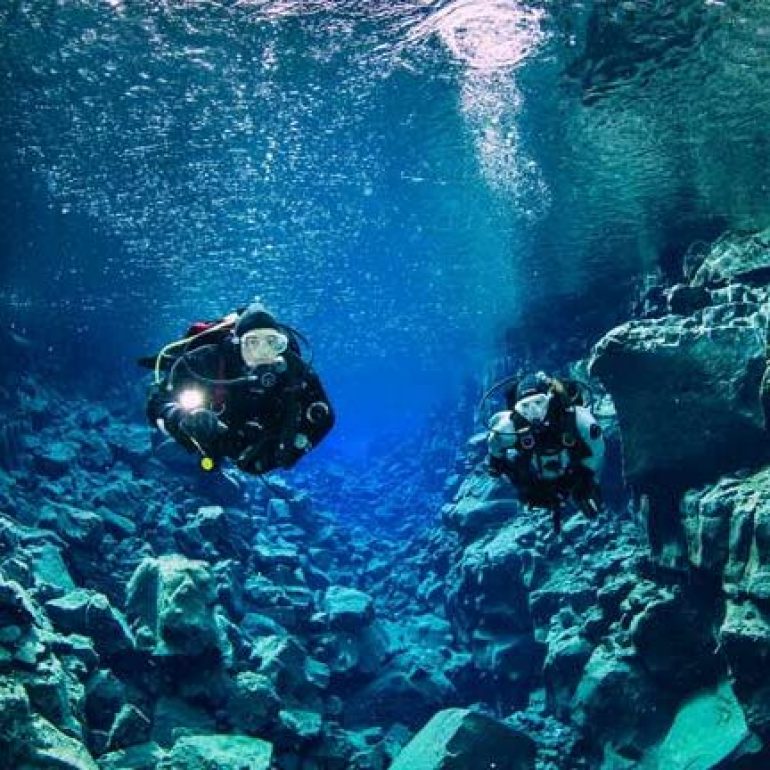 2 plongeurs dans la fissure de David en Islande