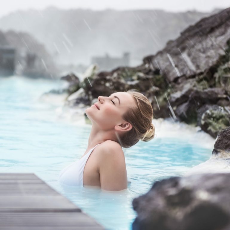 Una mujer disfrutando de un baño en el spa Blue Lagoon de Islandia.